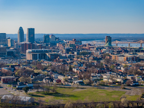 Aerial view of the Louisville skyline featuring skyscrapers residential neighborhoods and bridges over the Ohio River under a clear blue sky Louisville Kentucky United States. Aerial view of the Louisville skyline featuring skyscrapers residential neighborhoods and bridges over the Ohio River under a clear blue sky Louisville Kentucky United States.