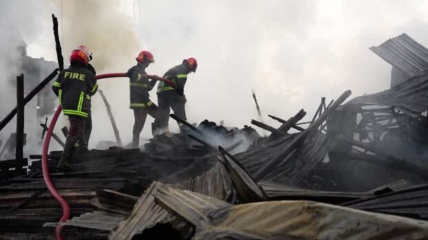 View of firefighters battling a blaze amidst smoke Bangladesh. View of firefighters battling a blaze amidst smoke Bangladesh.