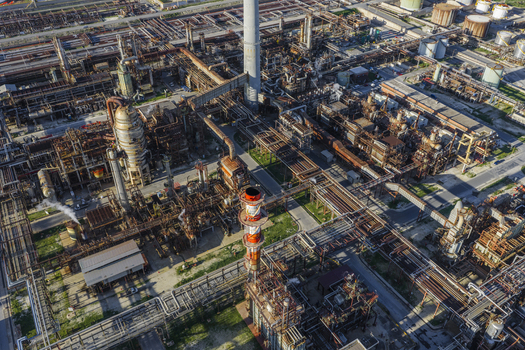 Aerial view of an industrial landscape with a network of pipes and structures under a hazy sky showcasing the stark contrast of metal and sky Syracuse Sicilia Italy.