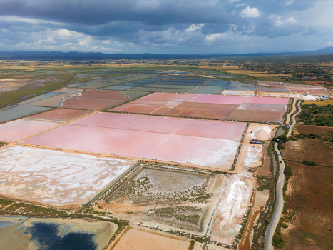 Aerial view of Salines des Trenc with vibrant pink and white salt evaporation ponds under a dramatic cloudy sky Campos Islas Baleares Spain. Aerial view of Salines des Trenc with vibrant pink and white salt evaporation ponds under a dramatic cloudy sky Campos Islas Baleares Spain.