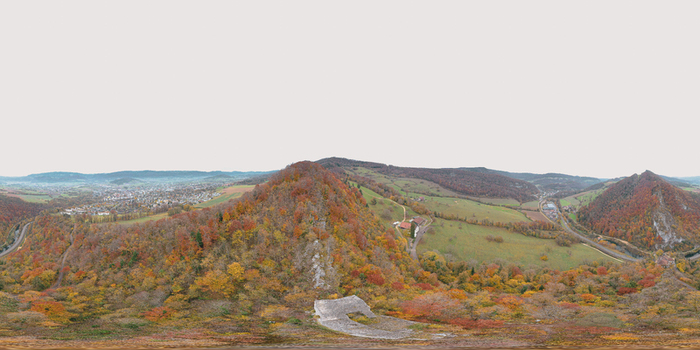 Aerial view of Chateau du Vorbourg perched on a rocky cliff surrounded by vibrant autumn foliage and rolling hills near Delemont Jura Switzerland. Aerial view of Chateau du Vorbourg perched on a rocky cliff surrounded by vibrant autumn foliage and rolling hills near Delemont Jura Switzerland.
