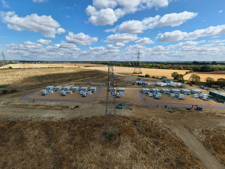 Aerial view of Eaton Socon Substation solar farm and battery energy storage systems with a prominent electricity pylon set in agricultural fields in St. Neots England United Kingdom. Aerial view of Eaton Socon Substation solar farm and battery energy storage systems with a prominent electricity pylon set in agricultural fields in St. Neots England United Kingdom.