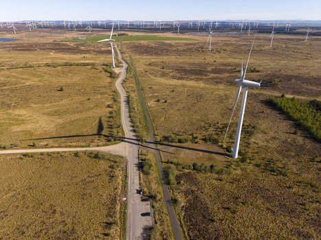 Aerial view of Eaglesham moor wind farm with large white turbines and access roads across the moorland Kilmarnock Scotland United Kingdom.
