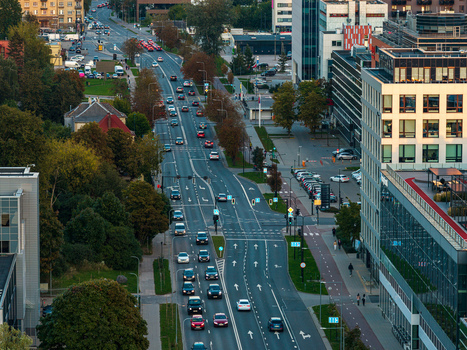 Aerial view of a busy city street with modern office buildings lush trees and flowing traffic in Vilnius Vilnius County Lithuania. Aerial view of a busy city street with modern office buildings lush trees and flowing traffic in Vilnius Vilnius County Lithuania.
