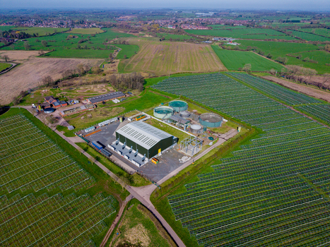Aerial view of Gnosall Heath solar farm with industrial buildings and storage tanks surrounded by green fields in Gnosall England United Kingdom. Aerial view of Gnosall Heath solar farm with industrial buildings and storage tanks surrounded by green fields in Gnosall England United Kingdom.