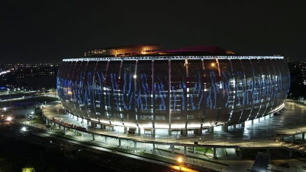 Aerial view of the Jakarta International Stadium illuminated at night with its distinctive facade and surrounding urban infrastructure in Tanjung Priok Jakarta Indonesia. Aerial view of the Jakarta International Stadium illuminated at night with its distinctive facade and surrounding urban infrastructure in Tanjung Priok Jakarta Indonesia.