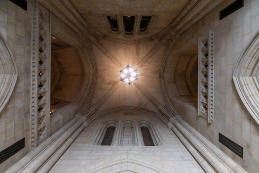 Washington District of Columbia United States 06 May 2025 View of the intricate vaulted ceiling and stone arches inside the Washington National Cathedral with a central hanging lantern.