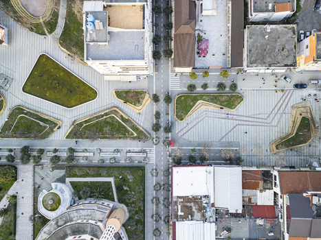 Aerial view of Parku Qendror featuring geometric green spaces and paved walkways in the city center of Fier Fier County Albania.