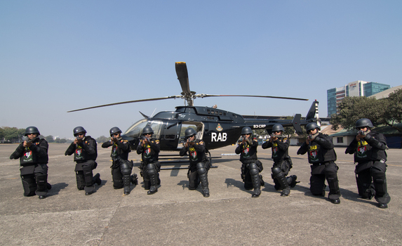 Dhaka Bangladesh 19 January 2017 View of Rapid Action Battalion RAB officers in tactical gear kneeling with rifles in front of a black helicopter at the RAB Headquarters. Dhaka Bangladesh 19 January 2017 View of Rapid Action Battalion RAB officers in tactical gear kneeling with rifles in front of a black helicopter at the RAB Headquarters.