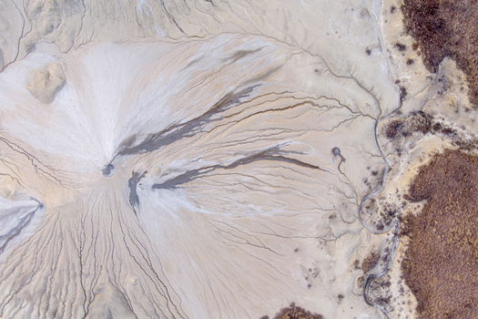 Aerial view of the mud volcanoes at Vulcanii Noroiosi Paclele Mari showing intricate patterns of dried mud flows and volcanic craters in Paclele Buzau County Romania.