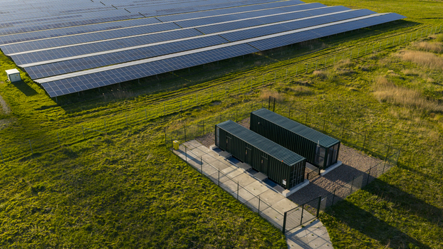 Aerial view of Solar park Delfzijl featuring rows of photovoltaic panels and green shipping containers on a grassy field in Farmsum Groningen Netherlands. Aerial view of Solar park Delfzijl featuring rows of photovoltaic panels and green shipping containers on a grassy field in Farmsum Groningen Netherlands.