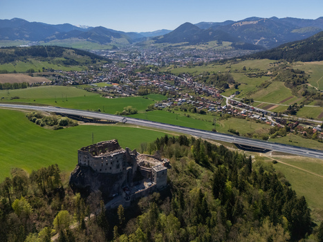 Aerial view of Castle Likava ruins on a forested hill with a highway and mountains in the background in Likavka Zilina Region Slovakia. Aerial view of Castle Likava ruins on a forested hill with a highway and mountains in the background in Likavka Zilina Region Slovakia.