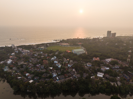 Aerial view of the coastal town of Galle featuring the cricket stadium and residential rooftops under a hazy sunset sky in Galle Southern Province Sri Lanka.