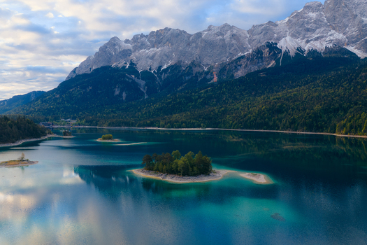Aerial view of the turquoise Eibsee lake with its small islands and the rocky Zugspitze mountain massif in the background Grainau Bavaria Germany. Aerial view of the turquoise Eibsee lake with its small islands and the rocky Zugspitze mountain massif in the background Grainau Bavaria Germany.