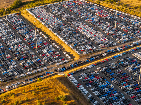 Aerial view of the automotive storage lot at Civitavecchia Port filled with rows of new cars parked on asphalt under golden hour light in Civitavecchia Lazio Italy. Aerial view of the automotive storage lot at Civitavecchia Port filled with rows of new cars parked on asphalt under golden hour light in Civitavecchia Lazio Italy.
