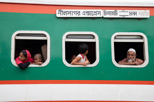 Dhaka Bangladesh 14 June 2018 View of passengers including children and an elderly man looking out of the windows of the Nilsagar Express train at Airport Railway Station. Dhaka Bangladesh 14 June 2018 View of passengers including children and an elderly man looking out of the windows of the Nilsagar Express train at Airport Railway Station.