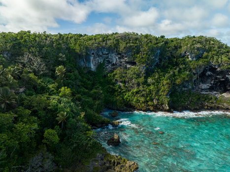 Aerial view of turquoise waters meet the rugged coastline vibrant green foliage blankets the cliffs Joking Lifou New Caledonia. Aerial view of turquoise waters meet the rugged coastline vibrant green foliage blankets the cliffs Joking Lifou New Caledonia.
