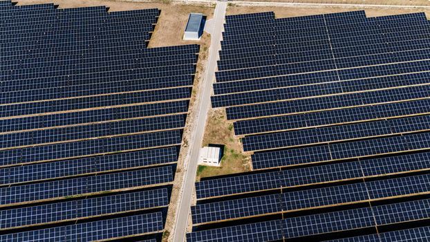 Aerial view of a large solar farm with rows of photovoltaic panels a central access road and small utility buildings in Temerin Vojvodina Serbia. Aerial view of a large solar farm with rows of photovoltaic panels a central access road and small utility buildings in Temerin Vojvodina Serbia.