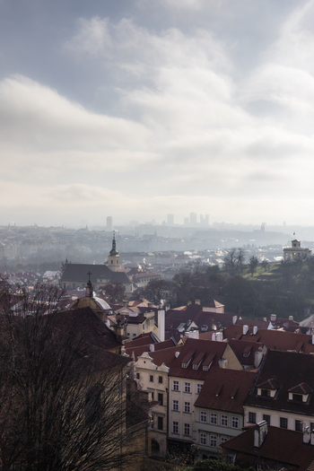 View of the historic red rooftops and church spires under a hazy morning sky Prague Prague Czechia. View of the historic red rooftops and church spires under a hazy morning sky Prague Prague Czechia.