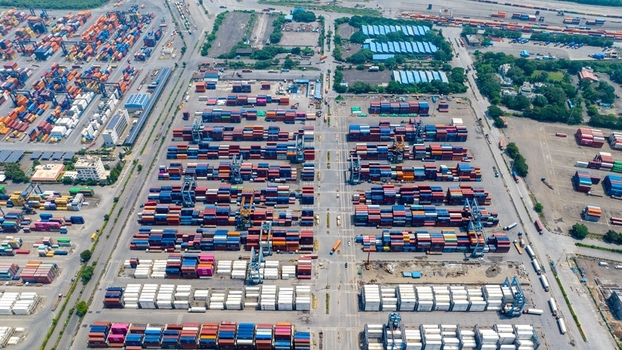 Aerial view of the Jawaharlal Nehru Port Authority container terminal with rows of colorful shipping containers and industrial gantry cranes in Juna Sheva Maharashtra India. Aerial view of the Jawaharlal Nehru Port Authority container terminal with rows of colorful shipping containers and industrial gantry cranes in Juna Sheva Maharashtra India.