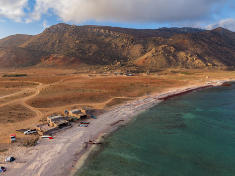 Aerial view of the serene coastline meeting rugged mountains under a vast sky creating a captivating contrast of colors and textures Dhi Hamri Socotra Yemen. Aerial view of the serene coastline meeting rugged mountains under a vast sky creating a captivating contrast of colors and textures Dhi Hamri Socotra Yemen.
