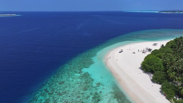 Aerial view of a tropical beach with turquoise water and coral reefs Maldives.