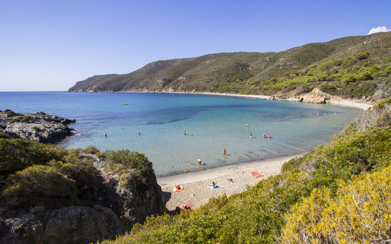 View of serene turquoise waters meet a sandy beach embraced by lush green hills a picturesque coastal scene unfolds in Lacona Elba Italy. View of serene turquoise waters meet a sandy beach embraced by lush green hills a picturesque coastal scene unfolds in Lacona Elba Italy.