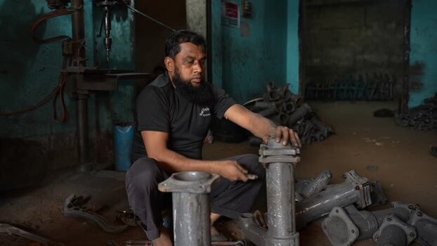 View of a worker assembling metal engine parts Bangladesh.