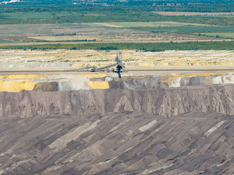 Aerial view of Tagebau Welzow Sud brown coal open pit mine with massive excavators layered earth and surrounding agricultural fields in Spremberg Brandenburg Germany. Aerial view of Tagebau Welzow Sud brown coal open pit mine with massive excavators layered earth and surrounding agricultural fields in Spremberg Brandenburg Germany.