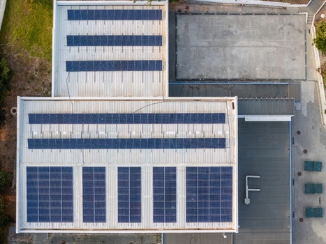 Aerial view of solar panels installed on a flat industrial building roof with metal corrugated surfaces in Lisboa Lisboa Portugal.