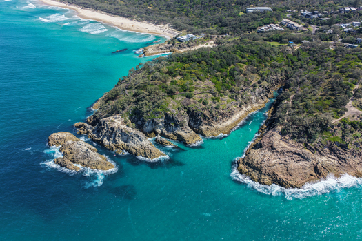 Aerial view of North Stradbroke Island featuring turquoise waters rocky headlands sandy beaches and lush coastal vegetation in Redland City Queensland Australia. Aerial view of North Stradbroke Island featuring turquoise waters rocky headlands sandy beaches and lush coastal vegetation in Redland City Queensland Australia.