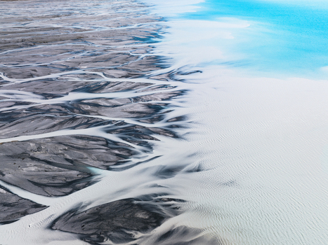 Aerial view of glacial rivers weaving through the stark landscape contrasting the turquoise waters of Lake Tekapo Lake Tekapo Canterbury Region New Zealand. Aerial view of glacial rivers weaving through the stark landscape contrasting the turquoise waters of Lake Tekapo Lake Tekapo Canterbury Region New Zealand.