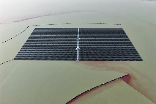 Aerial view of a large floating solar power plant on a calm lake featuring rows of photovoltaic panels and floating walkways in Dulmen North Rhine Westphalia Germany. Aerial view of a large floating solar power plant on a calm lake featuring rows of photovoltaic panels and floating walkways in Dulmen North Rhine Westphalia Germany.