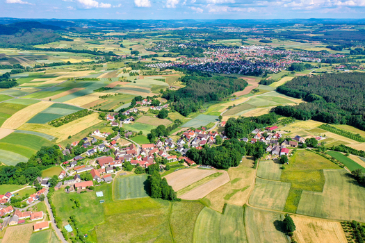 Aerial view of the village surrounded by vibrant agricultural fields and lush green forests in the countryside Neunkirchen am Brand Bavaria Germany. Aerial view of the village surrounded by vibrant agricultural fields and lush green forests in the countryside Neunkirchen am Brand Bavaria Germany.