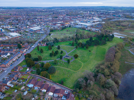 Aerial view of Doxey Marshes nature reserve with green fields trees and a small historic building surrounded by residential areas in Stafford England United Kingdom. Aerial view of Doxey Marshes nature reserve with green fields trees and a small historic building surrounded by residential areas in Stafford England United Kingdom.