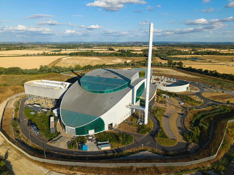 Aerial view of the Energy Recovery Facility with a tall chimney surrounded by rural fields and paved access roads in Bicester England United Kingdom.