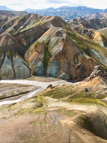 Aerial view of Landmannalaugar with its vibrant rhyolite mountains mossy green slopes and a winding river valley in Hella Rangarthing ytra Iceland. Aerial view of Landmannalaugar with its vibrant rhyolite mountains mossy green slopes and a winding river valley in Hella Rangarthing ytra Iceland.