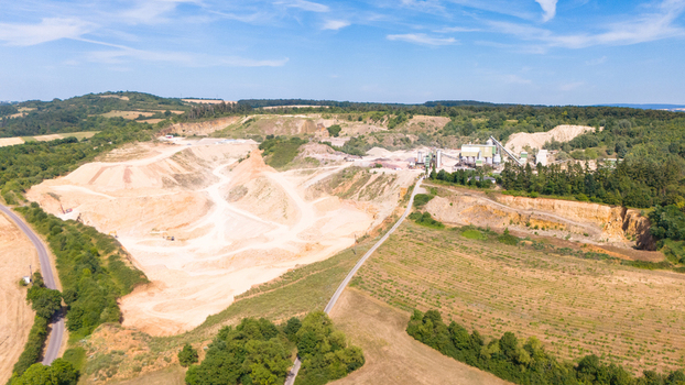Aerial view of a limestone quarrying operation with extraction pits processing facilities and surrounding rural landscape in Trier Saarburg Rhineland Palatinate Germany.