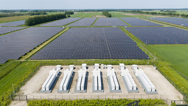 Aerial view of a large solar farm with rows of photovoltaic panels and a battery energy storage system in the foreground in Wanneperveen Overijssel Netherlands.