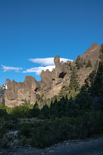 View of the unique rock formations along Ruta Provincial 63 featuring rugged cliffs sparse evergreen trees and a clear blue sky in the Patagonian landscape Neuquen Argentina. View of the unique rock formations along Ruta Provincial 63 featuring rugged cliffs sparse evergreen trees and a clear blue sky in the Patagonian landscape Neuquen Argentina.