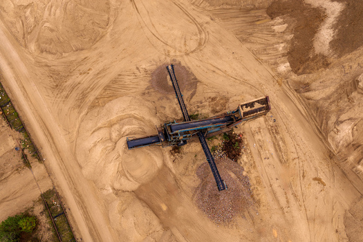 Aerial view of an industrial conveyor belt machine sorting sand and gravel in a quarry with tire tracks on the ground in Nemencine Vilnius County Lithuania. Aerial view of an industrial conveyor belt machine sorting sand and gravel in a quarry with tire tracks on the ground in Nemencine Vilnius County Lithuania.
