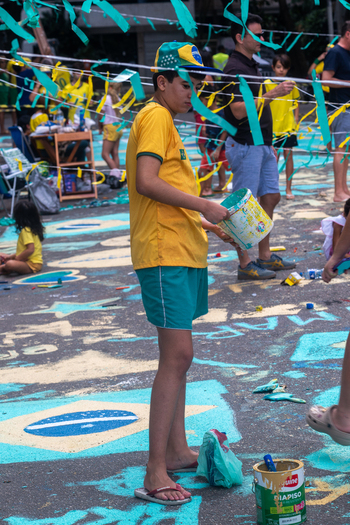 Rio de Janeiro Brazil 13 June 2026 View of a boy in a Brazil jersey holding a paint bucket on a street decorated with paintings and streamers for the World Cup 2026.