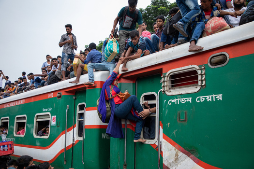 Dhaka Bangladesh 15 June 2018 View of people crowded on the roof of a Bangladesh Railway train at Airport Railway Station with a woman being helped up. Dhaka Bangladesh 15 June 2018 View of people crowded on the roof of a Bangladesh Railway train at Airport Railway Station with a woman being helped up.