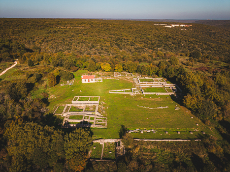 Aerial view of the ancient Roman ruins stand in stark contrast to the vibrant green landscape with a small building nearby Istria County Croatia.