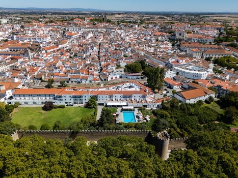Aerial view of the historic city of Evora with ancient stone walls terracotta rooftops and a swimming pool in the foreground Evora Evora District Portugal. Aerial view of the historic city of Evora with ancient stone walls terracotta rooftops and a swimming pool in the foreground Evora Evora District Portugal.