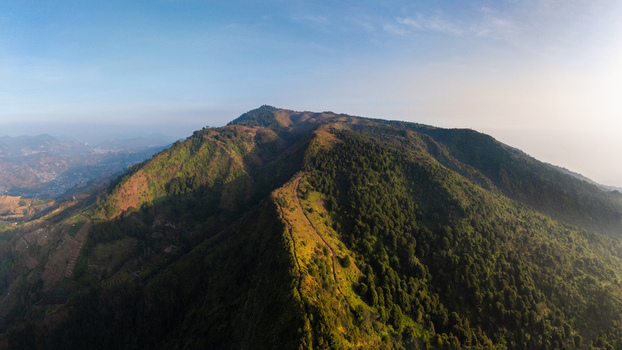 Aerial view of the lush green mountain slopes and ridge at Sunrise Camp Gunung Prau Kecamatan Kejajar Jawa Tengah Indonesia.