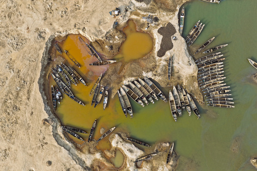 Aerial view of Jadukata River with numerous wooden boats moored along the sandy and muddy riverbanks in Sunamganj Sylhet Division Bangladesh. Aerial view of Jadukata River with numerous wooden boats moored along the sandy and muddy riverbanks in Sunamganj Sylhet Division Bangladesh.