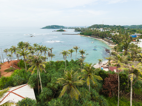 Aerial view of Coconut Tree Hill and the tropical coastline with palm trees and turquoise ocean water in Mirissa Southern Province Sri Lanka. Aerial view of Coconut Tree Hill and the tropical coastline with palm trees and turquoise ocean water in Mirissa Southern Province Sri Lanka.