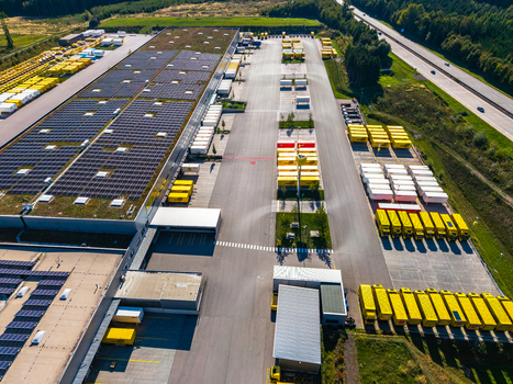 Aerial view of Logistikzentrum Allhaming with a large warehouse solar panels rows of yellow and white shipping containers and parking area in Allhaming Oberosterreich Austria. Aerial view of Logistikzentrum Allhaming with a large warehouse solar panels rows of yellow and white shipping containers and parking area in Allhaming Oberosterreich Austria.