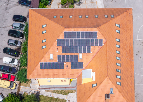 Aerial view of Vevchani featuring a building roof covered with solar panels and cars parked in the adjacent lot in Vevchani Vevcani Municipality North Macedonia. Aerial view of Vevchani featuring a building roof covered with solar panels and cars parked in the adjacent lot in Vevchani Vevcani Municipality North Macedonia.